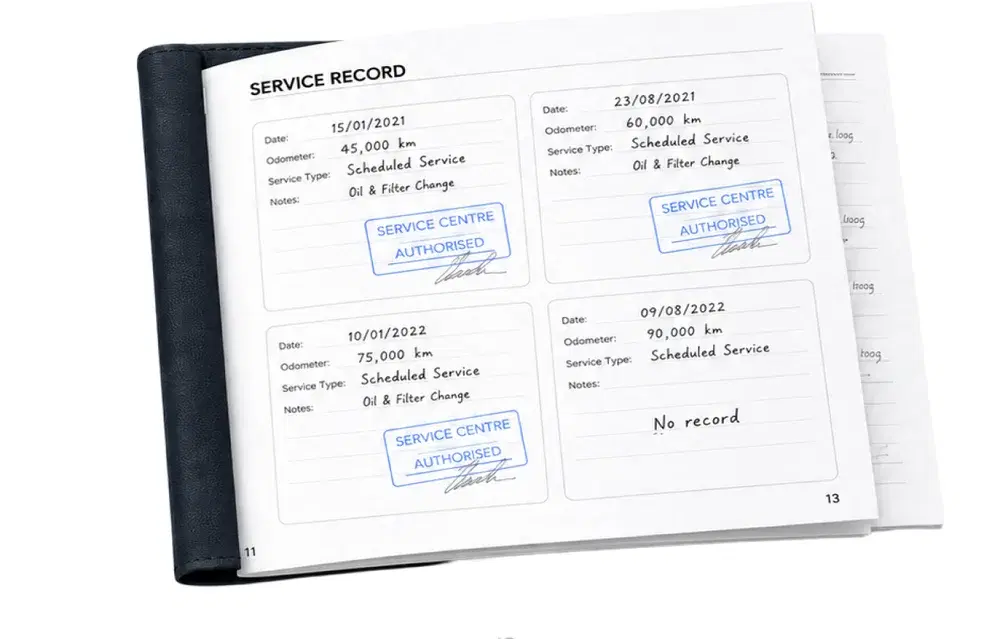 An open paper service logbook with handwritten entries, workshop stamps and one page reading no record